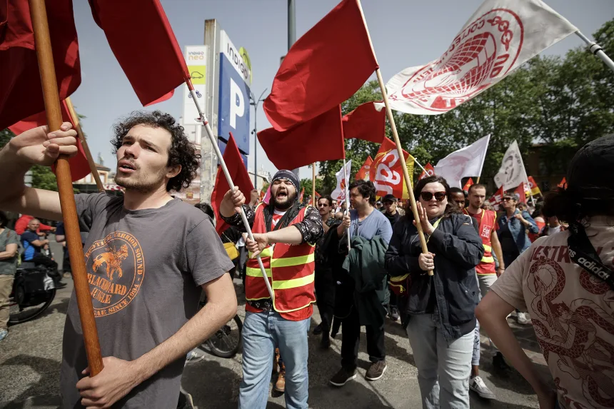 Para penunjuk perasaan mengibarkan bendera semasa perhimpunan memperingati Hari Pekerja Sedunia di Toulouse, barat daya Perancis, pada 1 Mei.